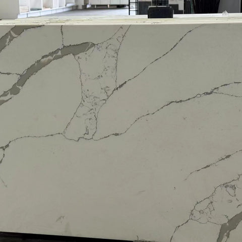 Calacatta Laza quartz slab with white base and gray veining in showroom display